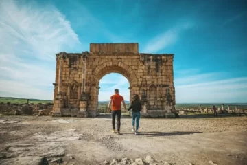 Couple exploring the ancient Roman ruins of Volubilis during a 5 Days Tour From Casablanca, showcasing Morocco’s rich history and breathtaking landscapes.