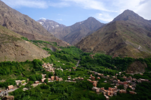 Scenic view of the Atlas Mountains in Morocco with lush green valleys and traditional Berber villages, a highlight of the 6 Days Tour From Casablanca.